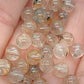 Perle en  cristal de roche avec inclusion en rutile et hématite A+ 6 mm - à l'unité
